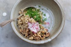 a bowl filled with rice, meat and vegtables next to a spoon