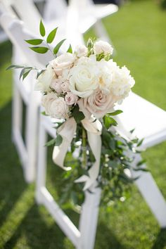 a bouquet of flowers sitting on top of a white chair in the middle of a field