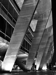 black and white photograph of people walking in front of an office building with large columns