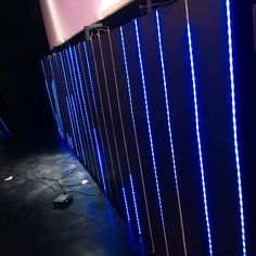 a wall that has some kind of blue light on it with wires attached to it