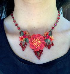 We call this color flame.  Bright red off set with hints of hot pink and orange make this a stunning necklace.  The center large flower is the focal point bordered with pretty drops on either side. The flowers are resin and are all individually hand painted. The whole piece is hand beaded with glass beads. This is a quality piece of jewelry that will last a life time. Created by designer Colleen Toland who has been creating her unique style of vintage jewelry for more than 30 years. All of our p Red Bohemian Flower Pendant Jewelry, Bohemian Red Flower Pendant Jewelry, Handmade Red Flower Necklace, Unique Red Wedding Necklaces, Unique Red Necklace For Wedding, Red Flower-shaped Beaded Necklace For Gift, Red Flower-shaped Beaded Necklaces For Gifts, Unique Red Flower-shaped Jewelry, Unique Red Flower Shaped Jewelry