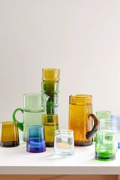 many different colored glass cups on a table