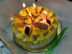 a yellow cake with candles on top of it