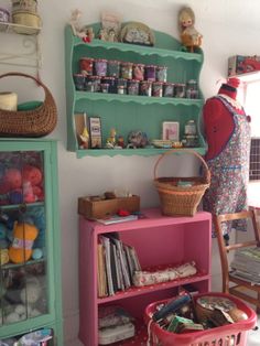 there is a shelf with many items on it and a basket in front of it