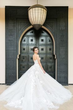 a woman standing in front of a door wearing a wedding dress