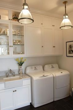 a washer and dryer sitting in a kitchen next to each other on top of cabinets