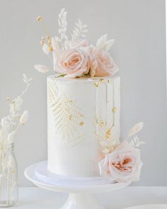 there is a white cake with pink flowers on it