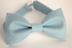 This trendy and stylish bow tie is great for so many occasions!Bow tie made of cotton fabric with a matching, adjustable neck strap. Style:• The Pre-Tied Bow Tie (with an adjustable neck strap)• The Clip-On Bow Tie (strapless, just a clip that you attach to the shirt collar)• Pocket square (handkerchief) All our bow ties can be made in the following sizes, just specify which size you need in a note at checkout: Sizes:Baby: 3.5" x 2"Kids: 4" x 2"Youth:  4.5" x 2.25Adult: 5" x 2.5"All our bow ties Dusty Blue Bow Tie, Bow Tie Ring, Blue Bowtie, Blue Groomsmen, Bowtie Wedding, Tie Ring, Groom Bowtie, Wedding Bow Tie, Ring Boy