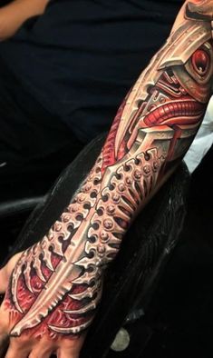 a man's arm with an intricate tattoo design on his left forearm and hand