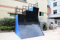 a blue skateboard ramp sitting in front of a building