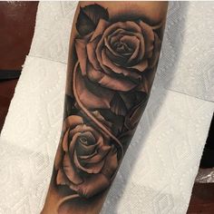 a black and grey rose tattoo on the arm