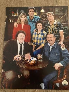 a group of people sitting around a table with drinks in front of them and smiling at the camera