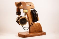 a wooden headphone stand on top of a white background with an electronic device attached to it