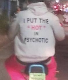 a person on a scooter wearing a sweatshirt that says i put the hot in sync