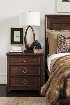 a bed room with a neatly made bed and two nightstands next to each other