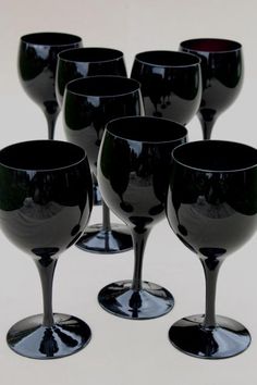 black wine glasses are lined up in a row