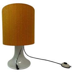 a table lamp with a wooden shade on the base and a cord plugged into it