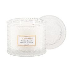 a candle that is white and has a label on the front, with an image of a