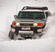 an suv driving through deep snow on the road