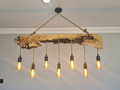 a light fixture made out of wood and hanging from the ceiling with five bulbs on it