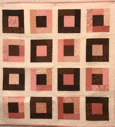 a pink and brown quilt with squares on it