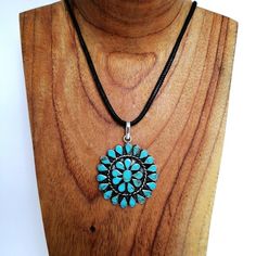 This stunning Squash Blossom pendant was handcrafted in Mexico.Each teardrop bezel is inlaid with turquoise coloured enamel enhanced with tiny brown flecks.Surrounding the centre blossom is a woven wire accent.Complete with an 18" inch black cord ready to wear! The pendant is approximately 2" inches long. This piece is silver plated.The pattern of the enamel may vary very slightly, they are all individually hand crafted.If you've got any questions don't hesitate to ask me.This pendant comes gift Southwestern Style Adjustable Teardrop Necklace, Adjustable Southwestern Turquoise Pendant Necklace, Bohemian Turquoise Teardrop Pendant Necklace, Bohemian Blue Turquoise Necklace With Concho, Bohemian Blue Turquoise Concho Necklace, Blue Bohemian Concho Necklace, Bohemian Blue Concho Necklace, Handmade Southwestern Necklace With Teardrop Pendant, Handmade Southwestern Teardrop Pendant Necklace