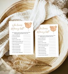 two wedding game cards sitting on top of a wooden bowl next to a white cloth