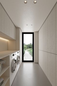 an empty laundry room with washer and dryer in the hallway next to it