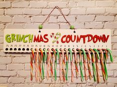 a sign hanging from the side of a brick wall with candy canes attached to it