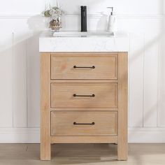 a bathroom vanity with two drawers and a marble counter top in front of a white wall