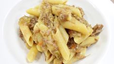 a white plate topped with pasta and meat