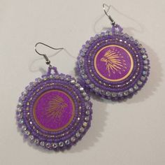 Hand made beaded earrings.  Colors: Purple & Gold Closure: Hook size: 2 inches Colorful Beaded Adjustable Earrings As Gift, Festive Beaded Hoop Earrings With Round Beads, Festive Beaded Hoop Earrings, Adjustable Colorful Beaded Earrings As Gift, Adjustable Colorful Beaded Earrings For Gifts, Gift Beaded Hoop Earrings, Handmade Purple Drop Clip-on Earrings, Adjustable Beaded Hoop Earrings As Gift, Adjustable Beaded Hoop Earrings For Gift