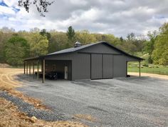 a large metal building sitting on top of a gravel road