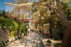 the walkway is lined with flowers and chandeliers hanging from it's sides