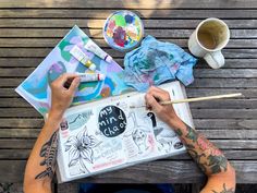 a person sitting at a table with some art supplies