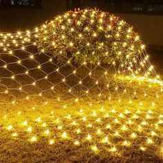 a wire fence with lights on it in the grass