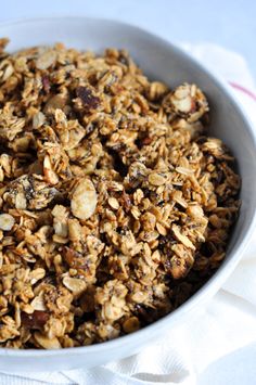 a white bowl filled with granola and nuts