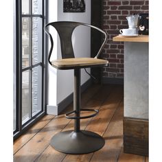 a modern bar stool with wooden seat and metal base in front of a brick wall