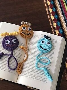 crocheted bookmarks made to look like cartoon characters on an open book