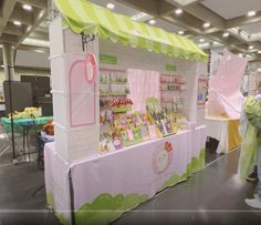 a woman standing in front of a booth selling children's books