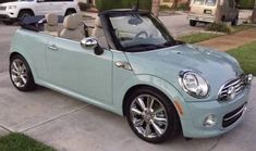 a light blue convertible car parked in front of a house