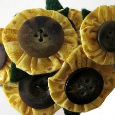 three yellow flowers with black buttons on them