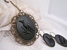 JUST LISTED Bronze settings Black on Black CROW Gothic Rockabilly Earring Set Cameo Necklace Pendant Victorian Jewelry substantial in size at just a little over 2 INCHES Long Center is 40mmx30mm **MATCHING ITEMS IN OUR STORE BADGE HOLDER BROOCH HAIR PINS - CLIPS** **PLEASE NOTE THIS LISTING IS FOR THE NECKLACE ONLY **thank you for taking the time to look at our items. Each item is handcrafted and attention to detail - We send each item in bubble packaging and with tracking to make sure items arr Rockabilly Earrings, Black Raven, Black Crow, Cameo Necklace, Black On Black, Black Skulls, Black Chain, Victorian Jewelry, Boutique Jewelry