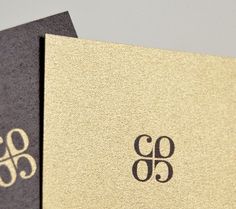 two black and gold business cards sitting next to each other