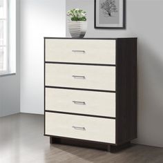 a white and brown chest of drawers next to a plant in a vase on top of it