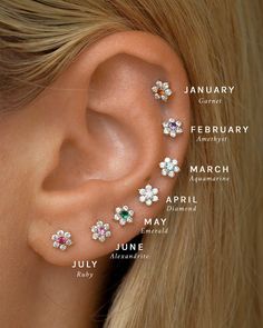 a woman's ear with four different piercings on it, including one flower