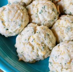 a blue plate topped with cheesy biscuits on top of a wooden table