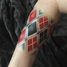 a person with a red and black tattoo on their arm