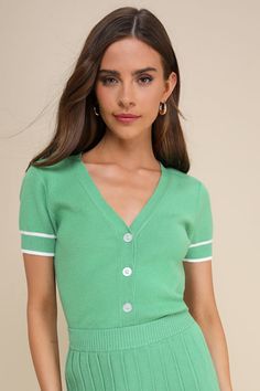 You'll be serving incredibly poised vibes every time you style the Lulus Marvelously Chic Green Short Sleeve Button-Up Cardigan! Stretchy sweater knit shapes this darling cardigan that boasts a V-neckline and short sleeves. A functional, three-button placket accents the fitted bodice, finishing at a slightly cropped hem. Ribbed knit and white striped details accent the cuffs and hem for cute finish. Pair with the matching skirt for a complete look! Fit: This garment fits true to size. Length: Si Spring V-neck Sweater With Button Closure, V-neck Cardigan With Buttons For Day Out, V-neck Sweater With Button Closure For Day Out, Green V-neck Cardigan For Day Out, Trendy Buttoned Knit Top For Spring, Trendy Spring V-neck Sweater With Buttons, Trendy Knit Top With Button Closure For Spring, Trendy Knit Top With Buttons For Spring, Trendy V-neck Sweater With Button Closure For Spring