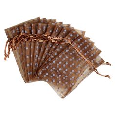 six brown and white polka dot paper napkins on a white background, with string tied around the edges